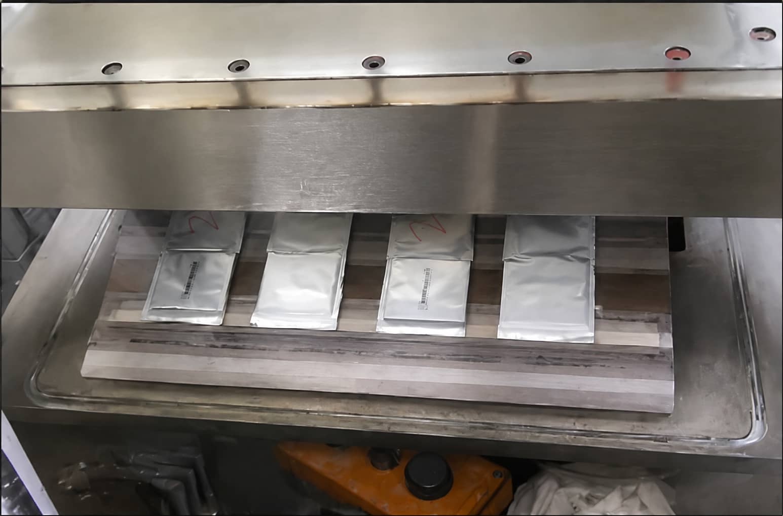 Pouch cell vacuum temporary sealing process removing gas from the gas bag and heat sealing cells after electrolyte injection during lithium battery manufacturing.