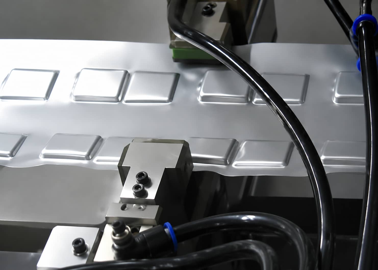 Pouch cell packaging film punch forming process using aluminum laminate film to create cavities for lithium-ion battery jelly roll assembly.