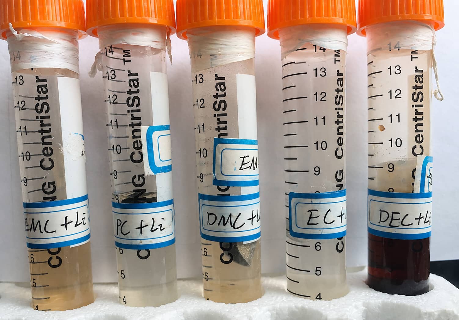 Lithium contact test comparing carbonate electrolyte solvents, showing obvious dark reddish-brown discoloration in the DEC group while EMC, DMC, EC and PC exhibit only mild color changes under the same conditions.