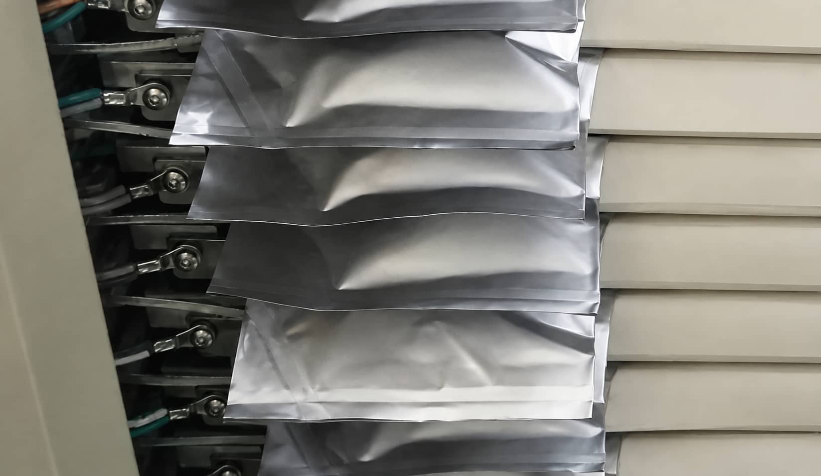 Swollen lithium-ion pouch cells observed during historical novel binder pilot-line evaluation, illustrating a cell-level manufacturing issue identified during scale-up testing.